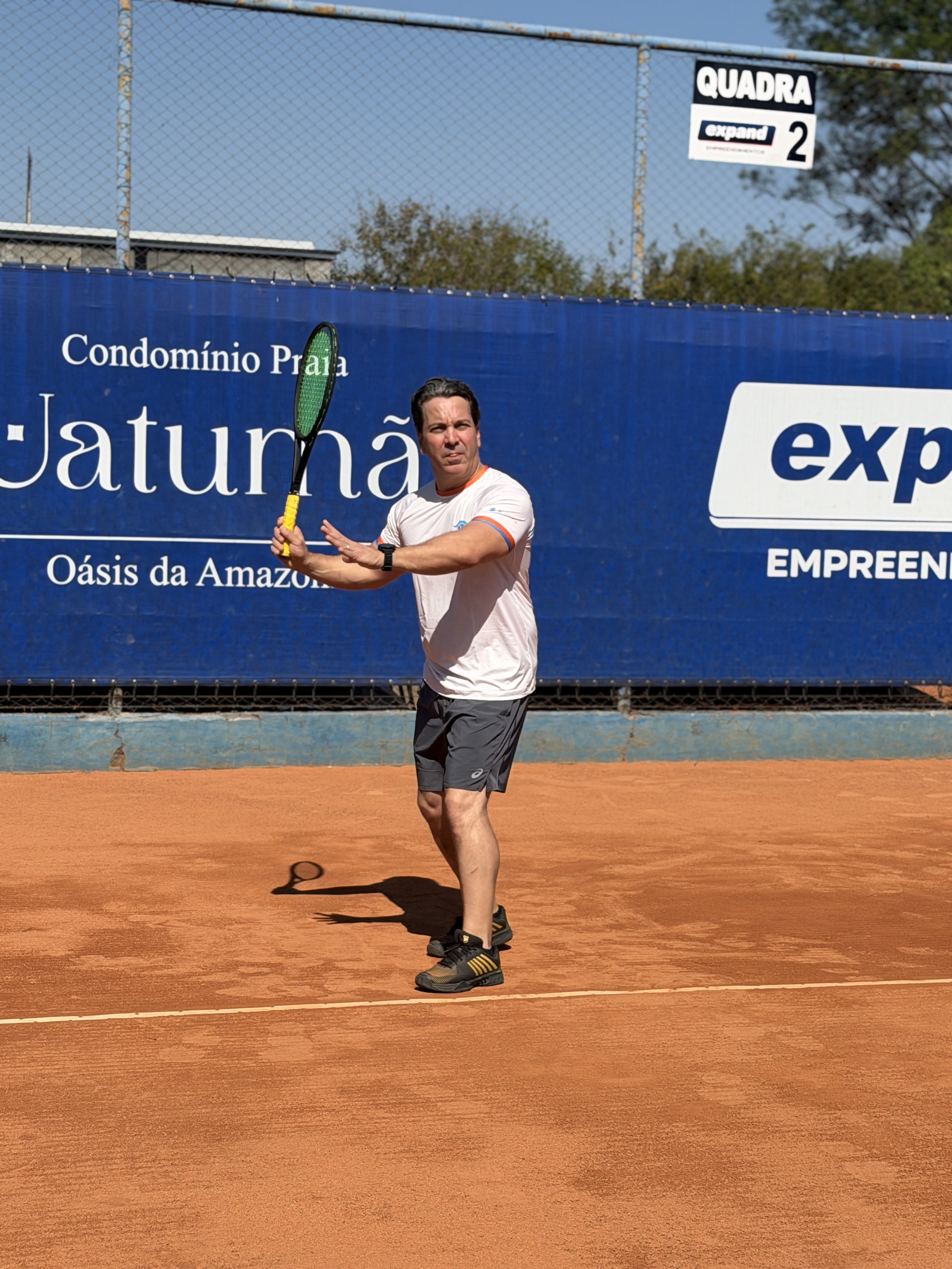 Aluno adulto em treino no saibro
